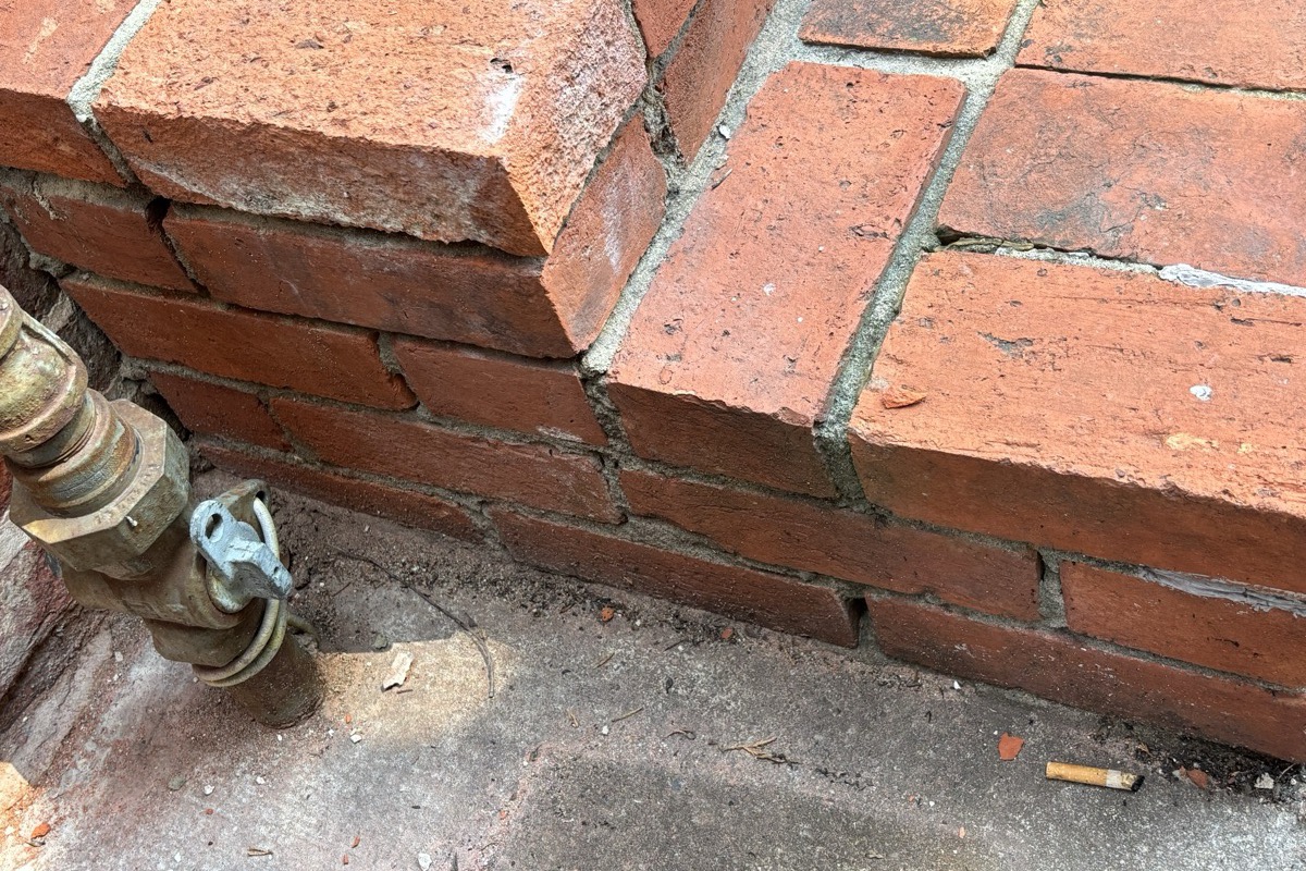 Close-up of an open weep hole at the base course of a brick veneer wall