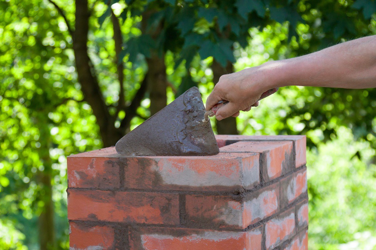 Charm City Masonry mason raking out failed mortar joints for repointing