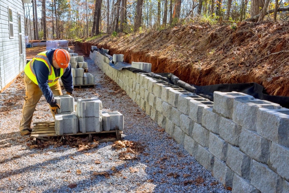 Charm City Masonry crew setting segmental block and gravel backfill for a Catonsville retaining wall